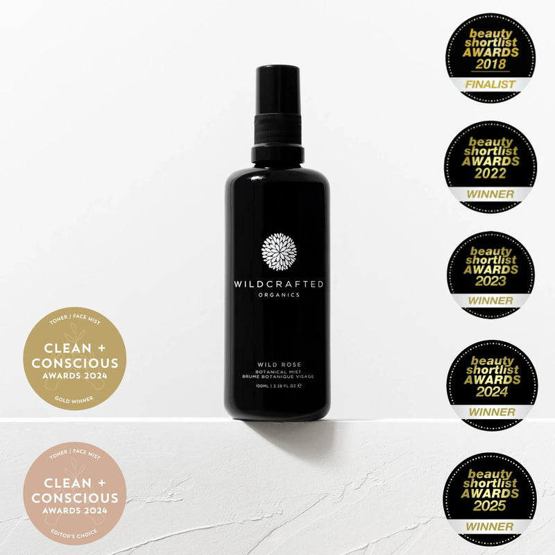 Black bottle labeled 'Wildcrafted Organics' with multiple awards on a white background