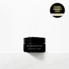 Black jar of Wildcrafted Bio-Retinol Crème on a white background with an award badge above it.
