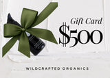 Gift card with a bottle of Wildcrafted Organics product and a green bow on a white background.