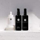 Three black bottles and a white dropper bottle with 'Wildcrafted Organics' branding on a light gray background.